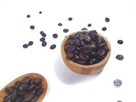 Roasted coffee bean on small wooden bowl and spoon isolated on white background with copy space photo