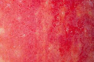 Texture of a red apple with water drops as background macro photography. photo