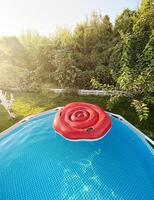 Frame pool with clear water for swimming in the garden in sunlight. Rest in a private house. photo