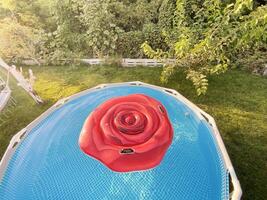 Frame pool with clear water for swimming in the garden in sunlight. Rest in a private house. photo