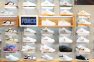 Abstract Blur Background of Row of shoes on display in shop. A view of a wall of shoes inside the store. Modern new stylish sneakers running shoes. photo