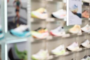 Abstract Blur Background of Row of shoes on display in shop. A view of a wall of shoes inside the store. Modern new stylish sneakers running shoes. photo