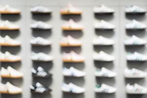 Abstract Blur Background of Row of shoes on display in shop. A view of a wall of shoes inside the store. Modern new stylish sneakers running shoes. photo