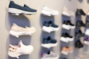 Abstract Blur Background of Row of shoes on display in shop. A view of a wall of shoes inside the store. Modern new stylish sneakers running shoes. photo