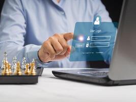 Businessman touching login button to the network system on a virtual screen photo