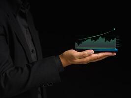 Digital increasing bar business graph growth on a smartphone on the palm while standing on a black background photo