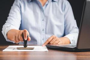 Businessman stamping approved on documents while sitting working in the office photo