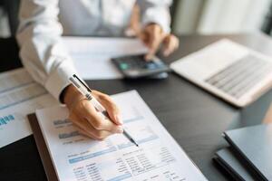 Close up of businessman hands signing or writing document paperwork and report Auditor analysis male professional hand making notes with Business Document. photo
