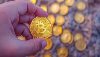 Hand holding a Bitcoin against a background of Bitcoins. Concept of cryptocurrency investment. photo
