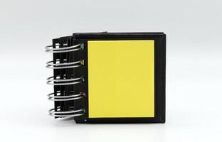 A black notepad with yellow pages sits open and ready for note-taking or creative brainstorming. photo