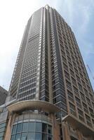 Tall Modern Skyscraper With Glass Windows Reaching Into The Sky On A Bright Sunny Day photo