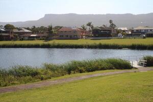Suburban Houses Along A Lake With Mountains In The Distance On A Clear Sunny Day photo