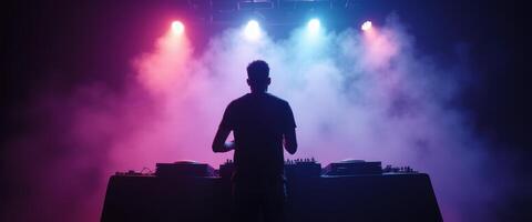 DJ Performing on Stage with Colorful Lights and Fog photo
