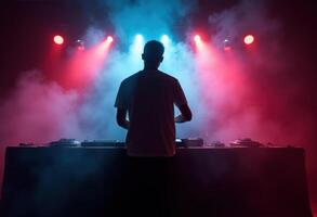 DJ performing with vibrant red and blue stage lights in a smoky atmosphere photo