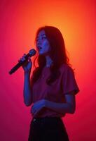 Young asian musician singing on gradient orange-red studio background in neon light. Concept of music, hobby, festival photo