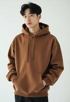 Portrait of Young Korean Man in Brown Hoodie with Hands in Pocket photo
