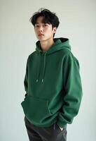Young Asian Man in Green Hoodie Posing with a Calm Expression photo