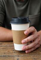Coffee paper cup in the man hands photo