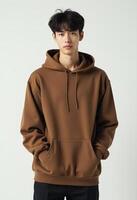 Portrait of Young Korean Man in Brown Hoodie with Hands in Pocket photo