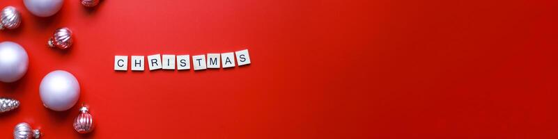 Banner Flat lay Christmas toys on a red background. Word christmas from letters on red background photo