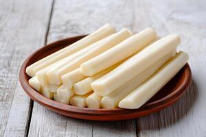 View of delicious string cheese on the plate on a wooden table photo
