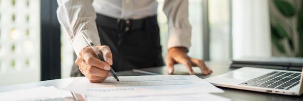 Close up of businessman hands signing or writing document paperwork and report Auditor analysis male professional hand making notes with Business Document. photo