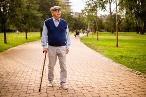 Portrait of happy senior man in park. He is relaxing and walking. photo