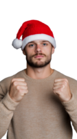 Man in beige sweater and Santa hat standing and showing fists in excitement on transparent background png