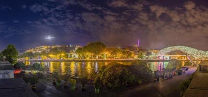 Peace Bridge in Tbilisi, Georgia, illuminated at night over the Kura River, captured in artificial light photo
