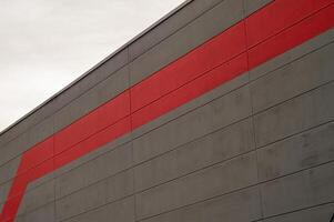 Red stripe cutting through a grey concrete modern building facade photo