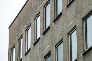 Grey concrete facade of modernist building showing windows and lines photo