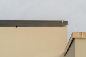 Building facade featuring metal gutter system and antennas photo