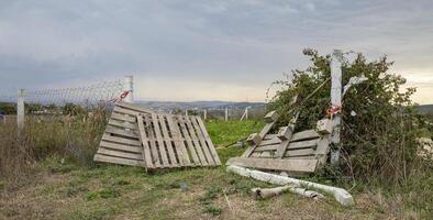 A fence and gate are broken down in a field photo