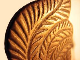 Closeup of engraving on an antique oil lamp photo