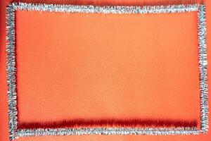 A red background for Christmas. With a frame made of zilver tree decoration. Christmas background. photo