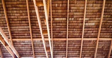 Rustic Wooden Ceiling with Exposed Beams Showcasing Natural Texture and Architectural Design in a Traditional Setting photo