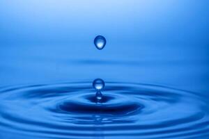 Captivating Close-Up of a Water Droplet Creating Ripples on a Calm Blue Surface in Minimalist Style photo