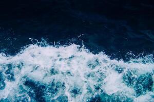 Dynamic Ocean Waves Crashing with Splashing Foam Against a Deep Blue Sea Background Capturing the Power and Beauty of Nature photo