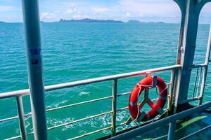 Scenic Ocean View from Ferry with Life Buoy and Distant Islands Under Clear Blue Sky on a Sunny Day photo
