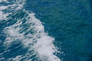 Aerial View of Ocean Waves Creating Dynamic Patterns on Deep Blue Water Surface photo