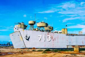 Rustic Naval Ship Docked on a Sunny Day with Clear Blue Sky and Weathered Hull photo
