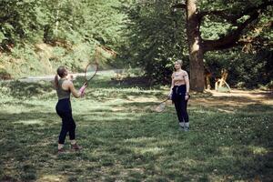 Mother And Daughter Playing Badminton In Nature photo
