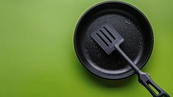 A frying pan with a spatula on top of it photo