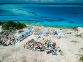 Rubbish dump with recycling and ocean in Maldives. Ecological problem. Drone view photo