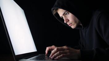 A hacker engages in cybercrime through his laptop on a dark backdrop while a young hacking prodigy battles him in an Internet Security Standoff photo