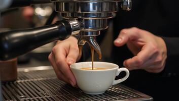 maker pours coffee in espresso machine photo