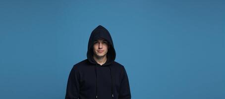 Hooded figure against blue backdrop photo