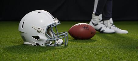 An American Football helmet lies on a grassy gameday setting alongside other sports equipment and protective gear photo