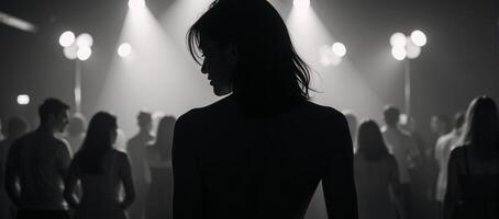 Womans silhouette amidst bustling nightclub setting photo