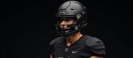 The image depicts a football player wearing allblack gear uniform helmet and face mask photo